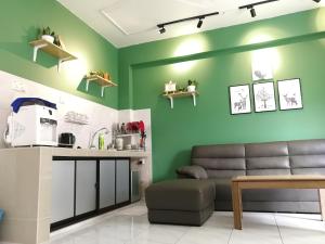 a living room with green walls and a couch at GVR Homestay 3 in Genting Highlands