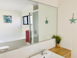 a bathroom with a sink and a mirror at DAYDREAMING Airlie Beach, Water views & only 200m to boardwalk. in Cannonvale