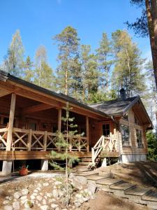 una cabaña de madera en el bosque con árboles en Rantahuvila Virranniemi en Vehkataipale