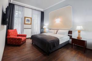 una stanza d'albergo con un letto e una sedia rossa di Tea for Two Hotel a Tbilisi City