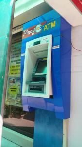 une machine à atm sur le côté d'un bâtiment dans l'établissement Villa Catalina Leisure resort, à Nabas 23 autres photos