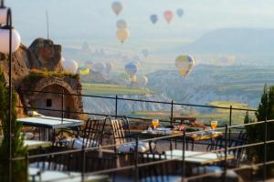 a bunch of hot air balloons flying in the sky at The Rupestral House Hotel in Uçhisar