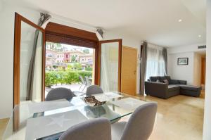 ein Wohnzimmer mit einem Glastisch und Stühlen in der Unterkunft Jardines de Montemar in Benissa