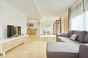 ein Wohnzimmer mit Sofa und Flachbildfernseher in der Unterkunft Jardines de Montemar in Benissa