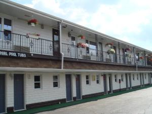 a white building with flowers on the balconies at Motor Court Motel in London