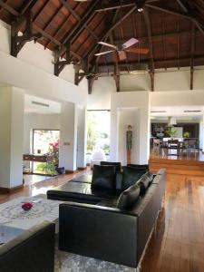 a living room with a black couch and a table at Villa Naiade in Bel Ombre