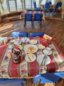 una mesa con platos de comida y sillas azules en Sevan Writers House en Sevan