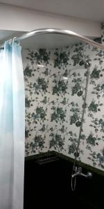 Baño con cortina de ducha y papel pintado con motivos florales en Lily's Apartment, en Ereván