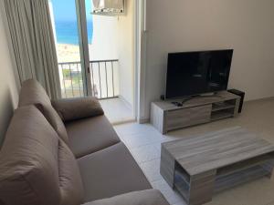 a living room with a couch and a flat screen tv at Acropole Algarve Beach Apartment in Portimão