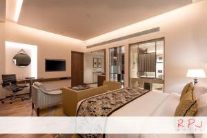 a hotel room with a large bed and a desk at RPJ Hotel Rajkot in Rajkot