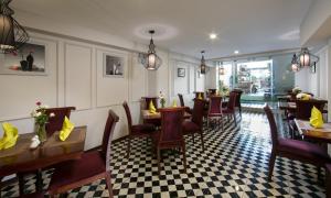 a restaurant with tables and chairs and a checkered floor at Vision Premier Hotel & Spa in Hanoi