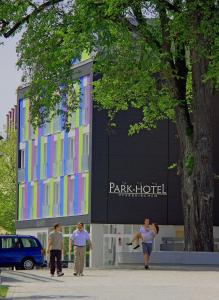 eine Gruppe von Menschen, die vor einem Gebäude spazieren in der Unterkunft Parkhotel Pfarrkirchen in Pfarrkirchen