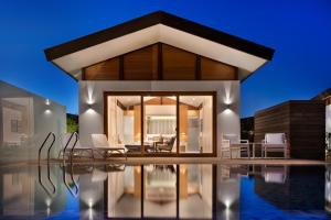 a villa with a swimming pool at night at The Setai Sea Of Galilee in Ein Gev