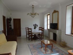 a living room with a table and a fireplace at Domaine de La Bessade in Le Bugue