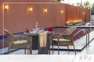 RPJ Hotel Rajkot في راجكوت: a table with two chairs and a tableaster yasteryasteryasteryasteryasteryastry