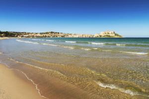 a view of a beach with a castle in the distance at Grand Hôtel De Calvi in Calvi