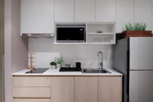 a small kitchen with a sink and a refrigerator at Seaview 2bed 2bath 19Fl at Veranda Residence Pattaya in Na Jomtien