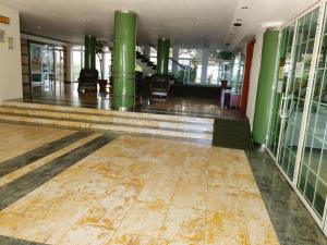 an empty lobby with green columns and a tile floor at Hotel Central in Mamaia