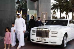 a man and a family standing next to a white limousine at Jumeirah Burj Al Arab Dubai in Dubai