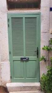 a green door on the side of a building at Le logis de la Fontaine in Ceyreste