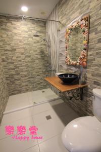 La salle de bains est pourvue de toilettes, d'un lavabo et d'un miroir. dans l'établissement 樂樂堂旅店, à Hengchun Old Town