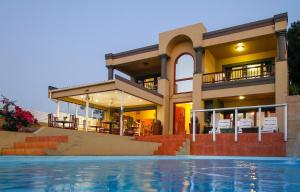 una casa con piscina frente a una casa en Virginia Forest Lodge, en Durban