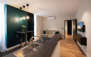 Monaco Central 1 bedroom appartement في بوسولاي: مطبخ مع حوض وغرفة معيشة