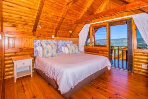 um quarto com uma cama num chalé de madeira em Abalone Lodges em Knysna