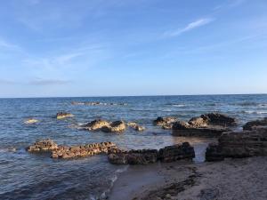 un grupo de rocas en el agua en una playa en La Lantana Nuova, en Flumini di Quartu