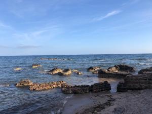 a group of rocks in the water on a beach at La Lantana Nuova in Flumini di Quartu