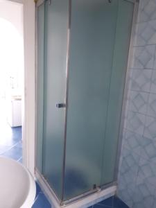 una doccia con porta in vetro in bagno di Marina Blu - Borgo storico Conca dei Marini a Conca dei Marini