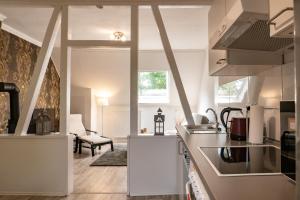 a kitchen with white appliances and a living room at Appartment Rheinaue in Duisburg