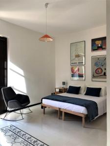 a bedroom with a large bed and a chair at ARDUINO AL TRE in Alghero