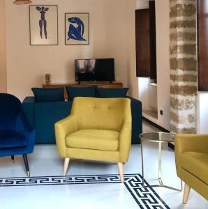 un soggiorno con divano blu e sedia gialla di ARDUINO AL TRE ad Alghero