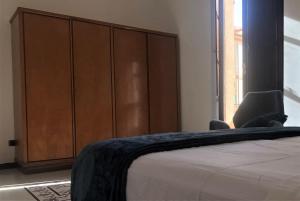 a bedroom with a bed and a large wooden cabinet at ARDUINO AL TRE in Alghero