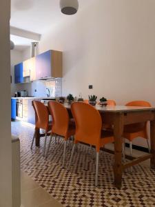 a kitchen with a wooden table and orange chairs at ARDUINO AL TRE in Alghero