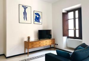 a living room with a tv and a blue couch at ARDUINO AL TRE in Alghero