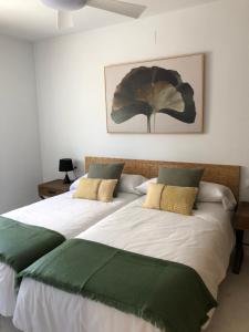 托雷莫利諾斯的住宿－Plaza del Remo Seewt&Beach，一间卧室配有两张带绿色和白色床单的床