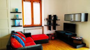 een woonkamer met een rode bank en een tv bij Coral & Turquoise in Pozzuoli