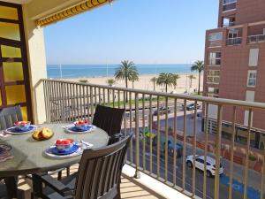 balkon ze stołem i krzesłami oraz widokiem na plażę w obiekcie NEPTUNO GANDIA Primera Línea - Alquiler Familias w mieście Playa de Gandia
