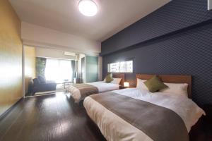 Cette chambre comprend 2 lits et une fenêtre. dans l'établissement FORESTAY Shinsaibashi, à Osaka
