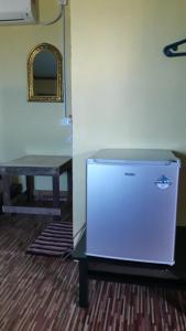 a small refrigerator in a room with a table at juara seaview chalet, kampung juara in Kampong Juara