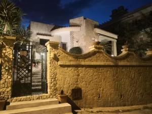 dom z kamienną ścianą z bramą w obiekcie Venti del Sud Appartamenti Affitti Brevi w mieście Noto Marina