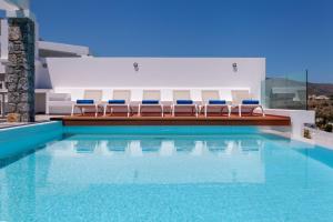 a swimming pool with blue chairs and a pool at Luxury Sunrise White Villa in Lindos