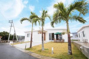 a house with two palm trees in front of it at パームヴィラ-貸切プライベート-最大10名様のバケーションステイ-駐車場付き in Yaese
