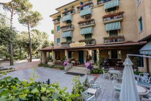 a hotel with tables and chairs in front of a building at Piccolo Hotel in Forte dei Marmi