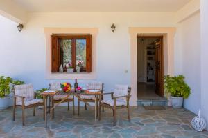 uma sala de jantar com mesa e cadeiras em Olive Grove Apartment em Skopelos