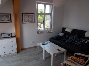 a living room with a black couch and a table at Apartament Jastarnia ul Bałtycka 26 in Jastarnia