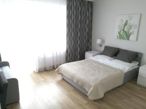 a white bedroom with a bed and a window at Pokoje Gościnne Abelard in Ustronie Morskie