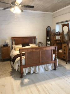 a bedroom with a wooden bed and a mirror at The Vineyard East in Joostenberg Vlakte